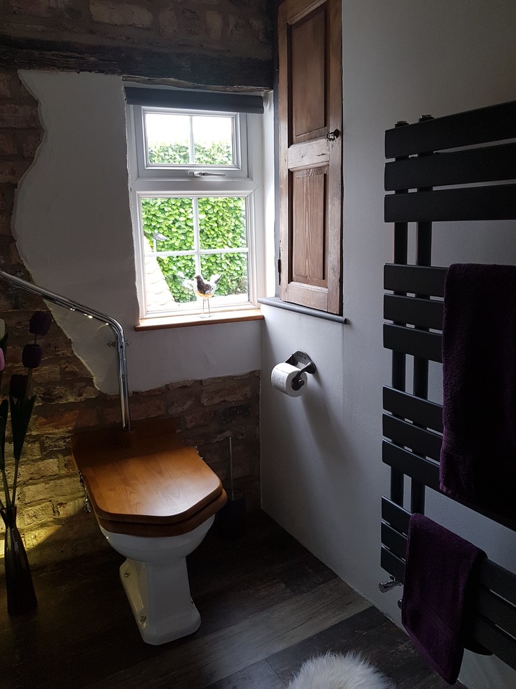 This is an example of a medium sized eclectic family bathroom in Other with open cabinets, medium wood cabinets, a freestanding bath, multi-coloured tiles, stone slabs, white walls, vinyl flooring, a vessel sink, wooden worktops, brown floors and a two-piece toilet.