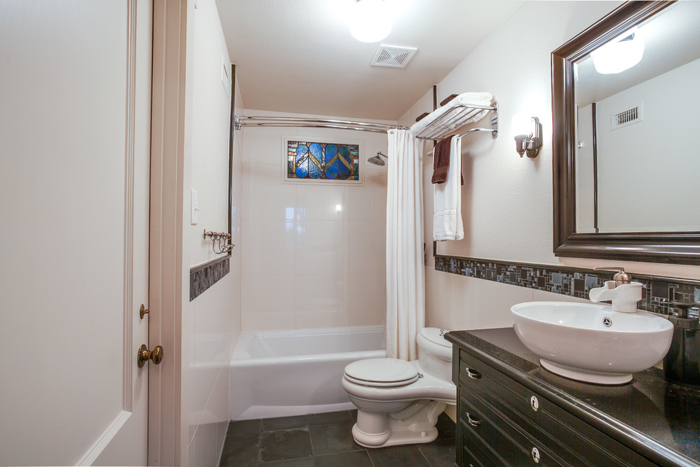 Cette photo montre une petite salle d'eau éclectique avec un placard en trompe-l'oeil, des portes de placard noires, un combiné douche/baignoire, un carrelage noir et blanc, des carreaux de céramique, un mur blanc, un sol en ardoise, une vasque et un plan de toilette en bois.