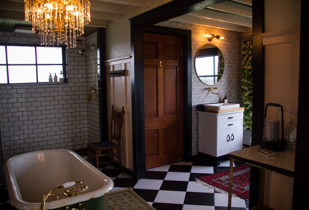Idéer för att renovera ett stort lantligt brun brunt en-suite badrum, med möbel-liknande, ett badkar med tassar, en öppen dusch, en toalettstol med hel cisternkåpa, svart och vit kakel, keramikplattor, rosa väggar, klinkergolv i keramik, ett fristående handfat, träbänkskiva, svart golv och dusch med duschdraperi