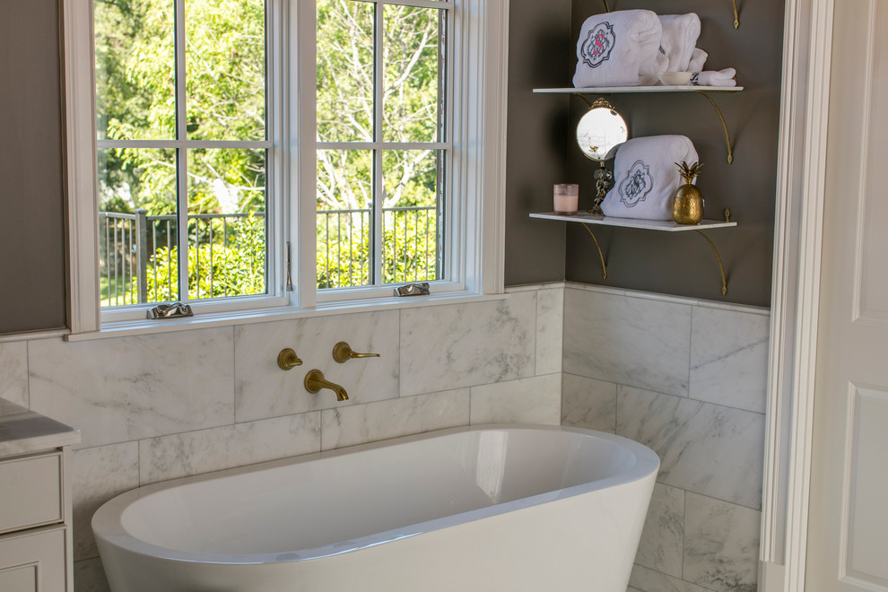 Exempel på ett mellanstort eklektiskt badrum med dusch, med luckor med profilerade fronter, vita skåp, ett fristående badkar, marmorkakel, grå väggar och marmorbänkskiva