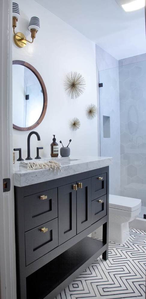 Example of a mid-sized eclectic master gray tile and cement tile concrete floor bathroom design in Los Angeles with shaker cabinets, blue cabinets, marble countertops, a one-piece toilet and white walls