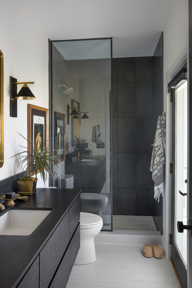 Idée de décoration pour une salle de bain design avec une douche ouverte, un lavabo encastré, aucune cabine, un placard à porte plane, des portes de placard noires, un carrelage blanc, un mur blanc, un sol blanc et un plan de toilette noir.