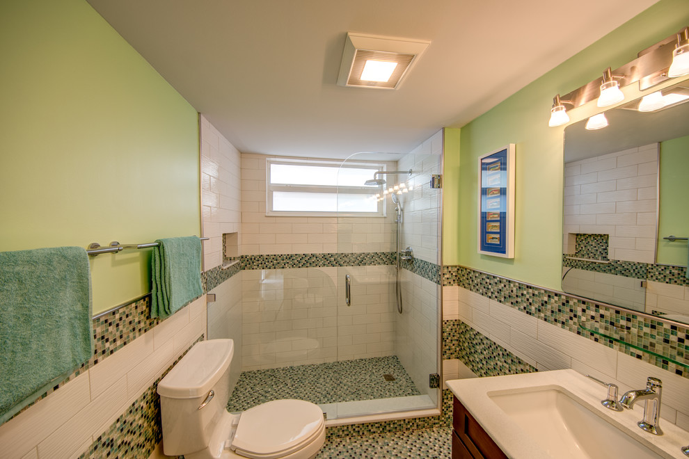 Example of a mid-sized eclectic 3/4 blue tile, green tile, multicolored tile, white tile and mosaic tile mosaic tile floor and multicolored floor alcove shower design in Columbus with shaker cabinets, medium tone wood cabinets, a two-piece toilet, green walls, an undermount sink, quartz countertops and a hinged shower door