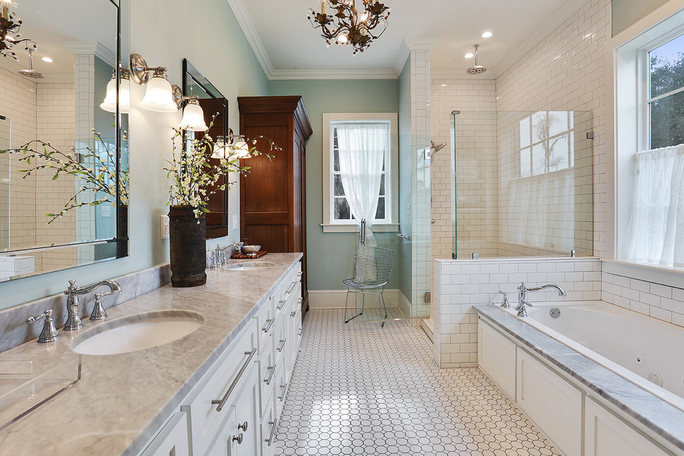 На фото: главная ванная комната в стиле неоклассика (современная классика) с фасадами в стиле шейкер, белыми фасадами, ванной в нише, угловым душем, серой плиткой, синими стенами, врезной раковиной и мраморной столешницей с
