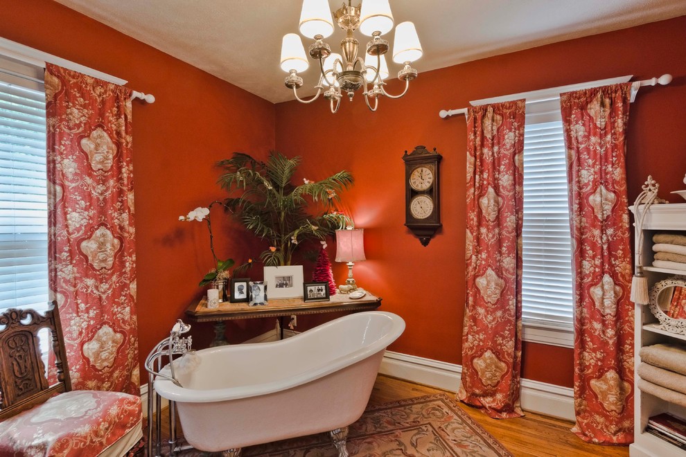 На фото: ванная комната среднего размера в классическом стиле с подвесной раковиной, ванной на ножках, раздельным унитазом, красными стенами, паркетным полом среднего тона и душевой кабиной с