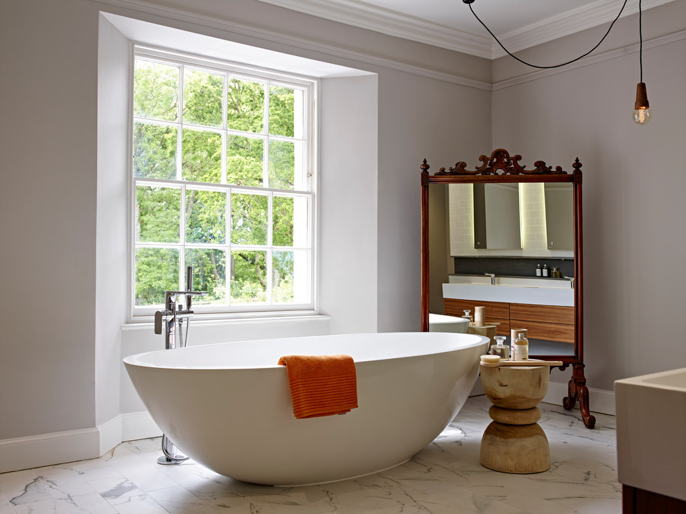 На фото: ванная комната среднего размера в восточном стиле с отдельно стоящей ванной, мраморным полом, подвесной раковиной, душем без бортиков, инсталляцией, разноцветной плиткой, керамогранитной плиткой и серыми стенами с