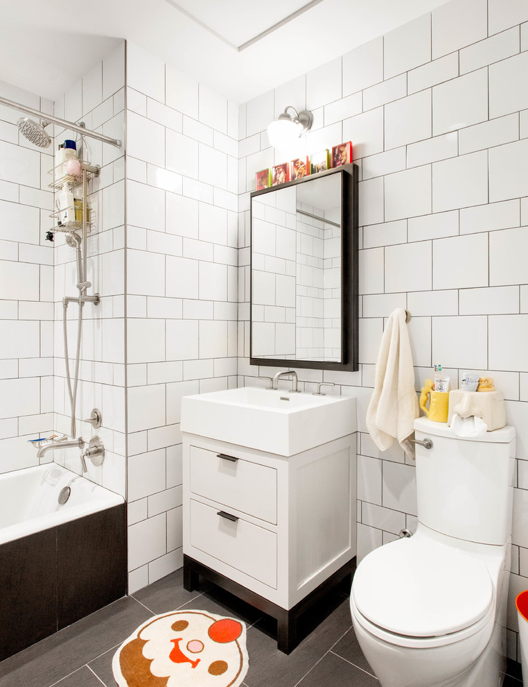 Inspiration för mellanstora eklektiska badrum med dusch, med släta luckor, vita skåp, ett badkar i en alkov, en dusch/badkar-kombination, en toalettstol med separat cisternkåpa, vit kakel, ett konsol handfat, grått golv, tunnelbanekakel, klinkergolv i porslin och dusch med duschdraperi