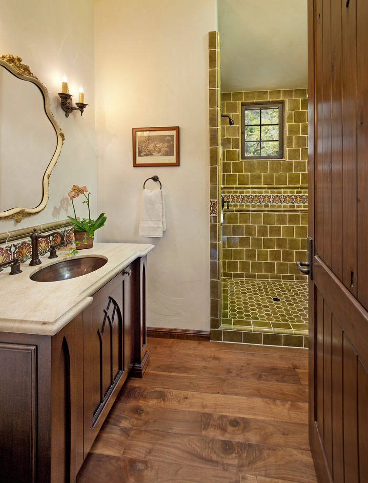 Mediterranes Badezimmer mit Granit-Waschbecken/Waschtisch und braunem Holzboden in Santa Barbara