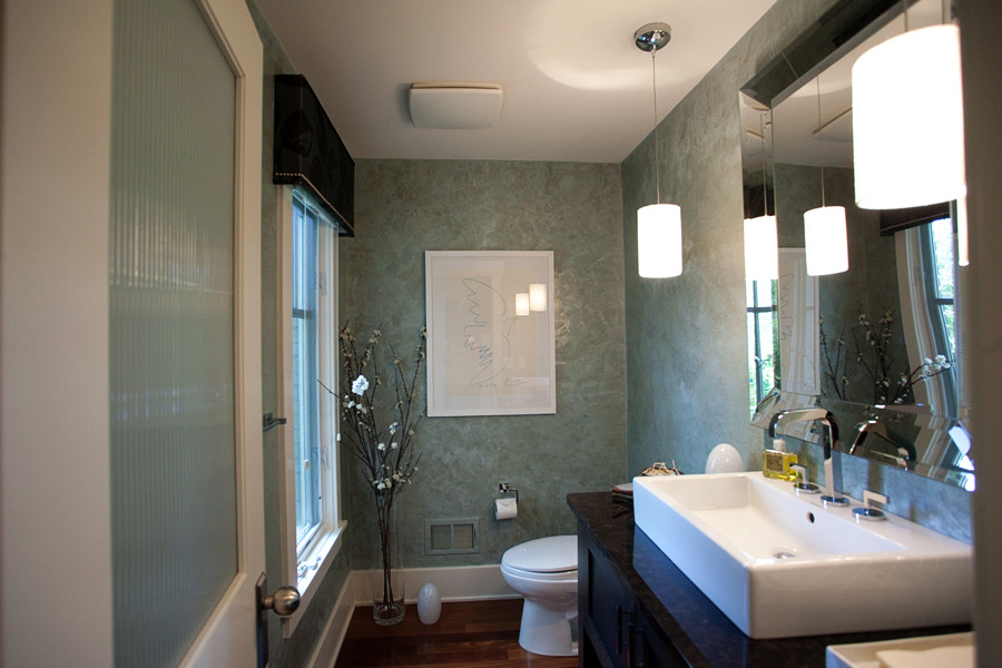 Modelo de cuarto de baño clásico renovado de tamaño medio con lavabo de seno grande, armarios tipo mueble, puertas de armario negras, encimera de granito, paredes azules, suelo de madera oscura y aseo y ducha