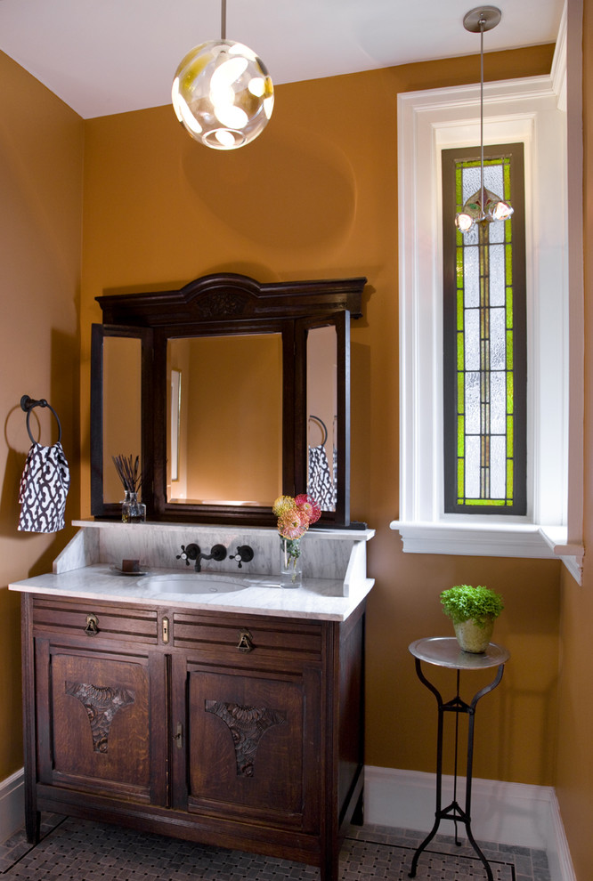 This is an example of a victorian bathroom in Boston with a submerged sink, recessed-panel cabinets, dark wood cabinets and orange walls.