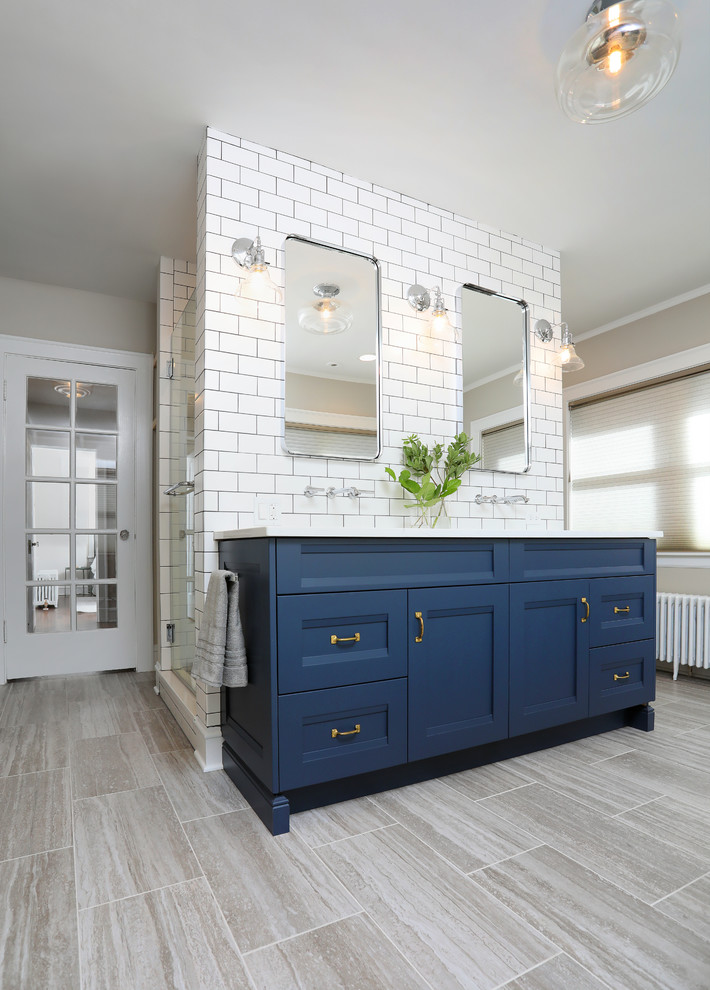 Imagen de cuarto de baño principal clásico renovado de tamaño medio con armarios con paneles empotrados, puertas de armario azules, baldosas y/o azulejos blancos, baldosas y/o azulejos de cerámica, paredes beige, suelo de baldosas de porcelana, lavabo bajoencimera, encimera de cuarzo compacto, suelo beige y encimeras blancas