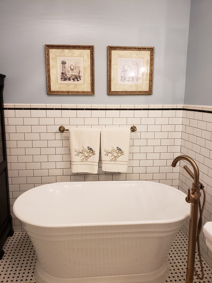 На фото: главная ванная комната среднего размера в классическом стиле с отдельно стоящей ванной, белой плиткой, плиткой кабанчик, серыми стенами, полом из керамогранита, консольной раковиной и разноцветным полом