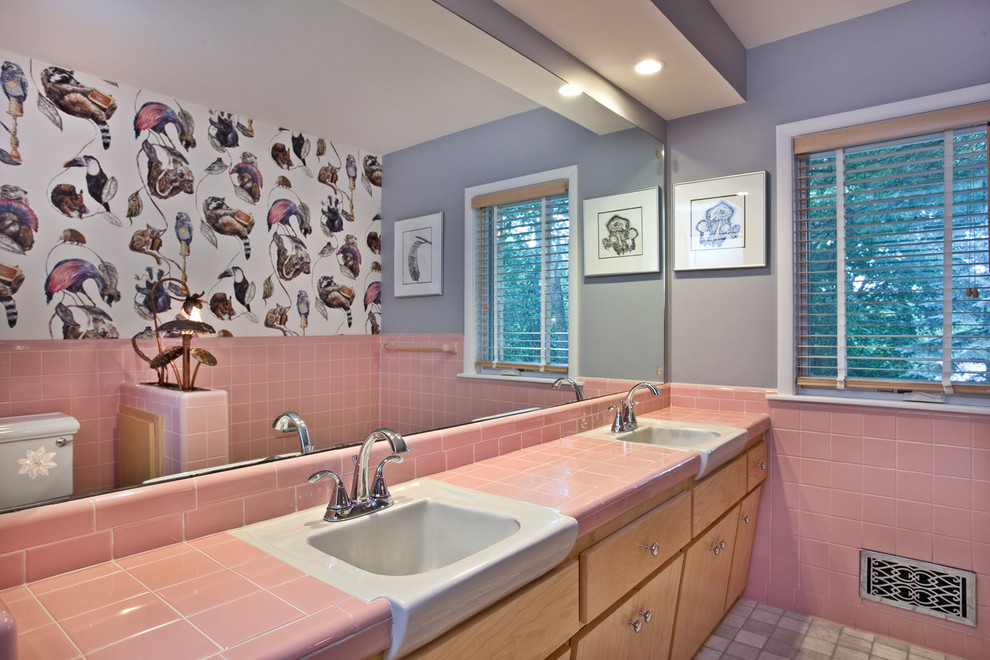 Aménagement d'une salle de bain principale éclectique en bois clair avec un placard à porte plane, un carrelage rose, des carreaux de céramique, un mur gris, un sol en carrelage de porcelaine, un lavabo intégré et un plan de toilette en carrelage.