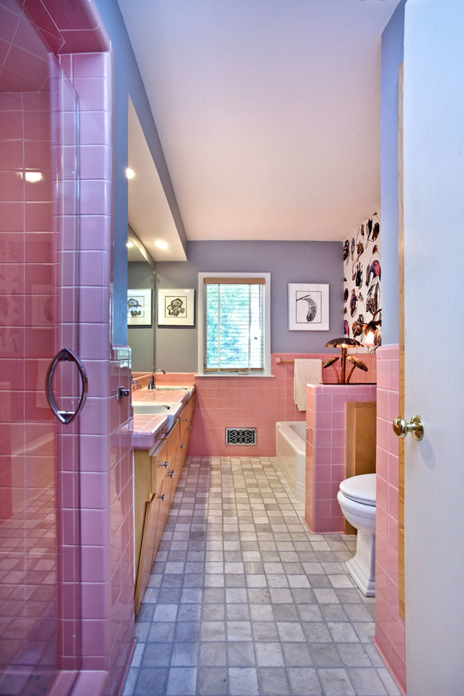 Example of an eclectic pink tile porcelain tile bathroom design in Minneapolis with flat-panel cabinets, light wood cabinets, a two-piece toilet, gray walls, an integrated sink and tile countertops