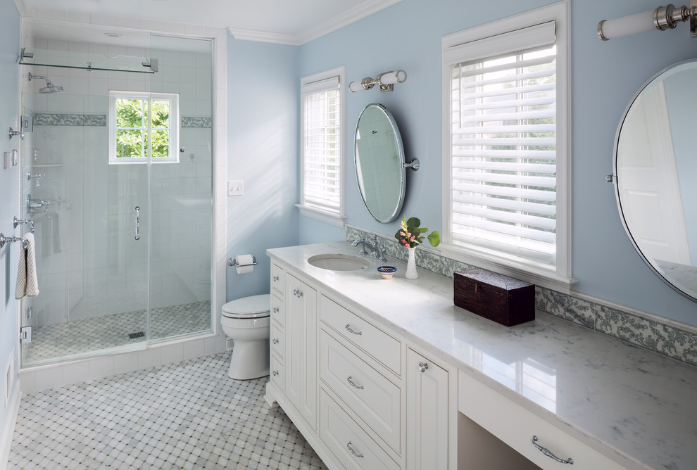 На фото: главная ванная комната в классическом стиле с фасадами с утопленной филенкой, белыми фасадами, душем в нише, разноцветной плиткой, синими стенами, врезной раковиной, мраморной столешницей, мраморным полом и душем с распашными дверями с
