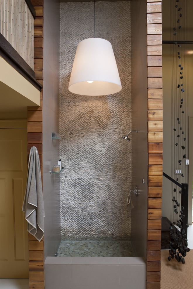 Réalisation d'une salle de bain design avec une douche ouverte, un carrelage gris, une plaque de galets, un sol en galet et aucune cabine.