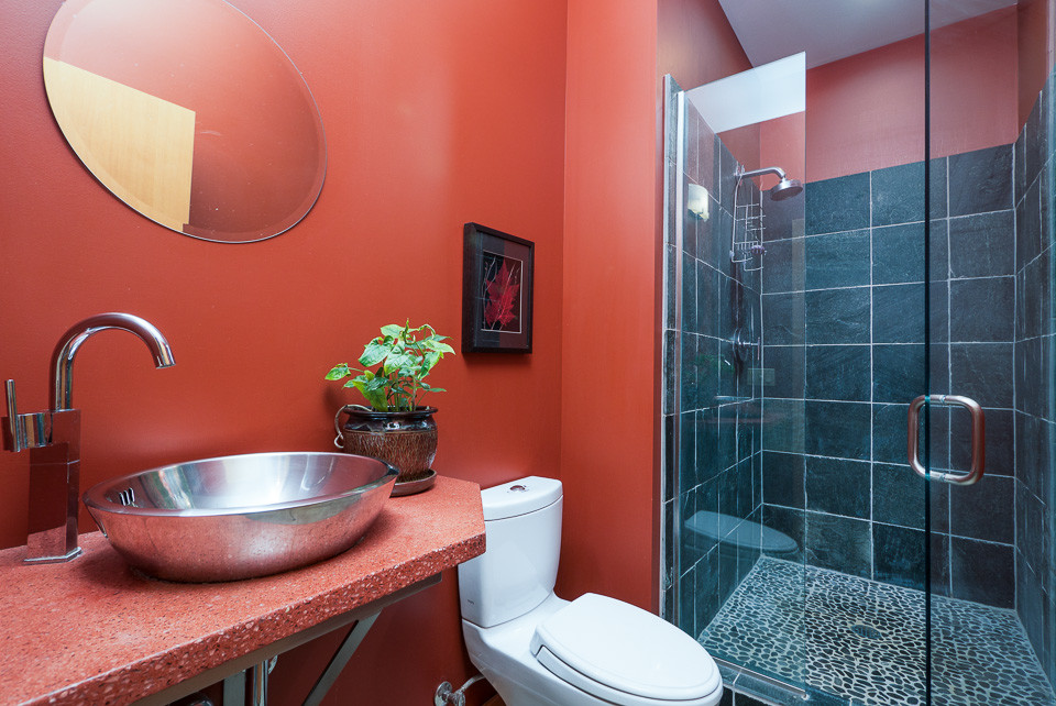 This is an example of a small modern family bathroom in Seattle with a vessel sink, an alcove shower, a one-piece toilet, black tiles and red walls.