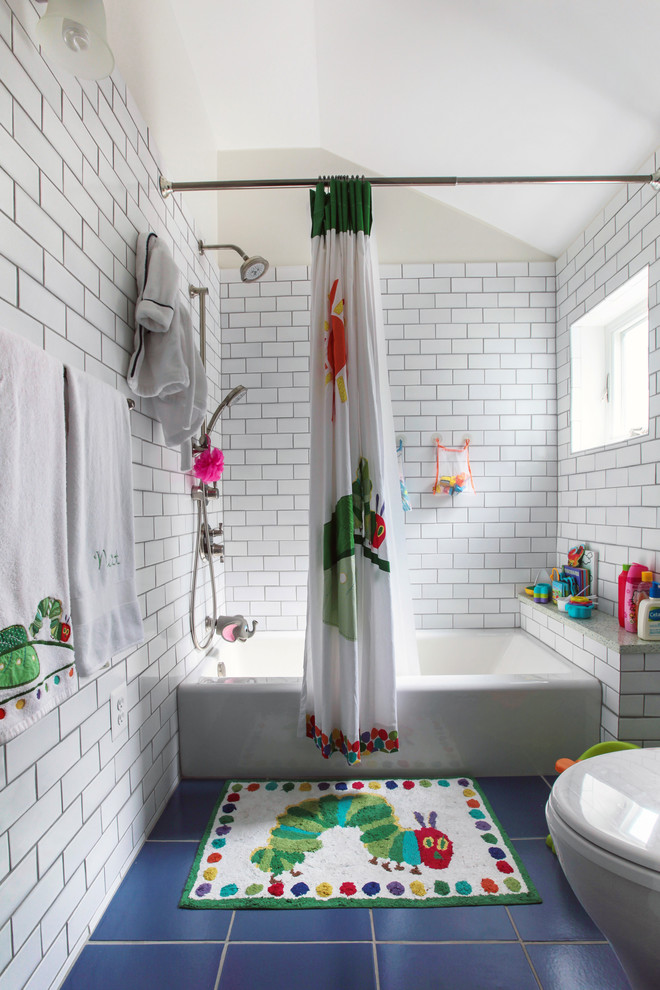 Exemple d'une salle de bain chic de taille moyenne pour enfant avec une baignoire en alcôve, un combiné douche/baignoire, un carrelage blanc, un carrelage métro, un sol en carrelage de porcelaine et un sol bleu.