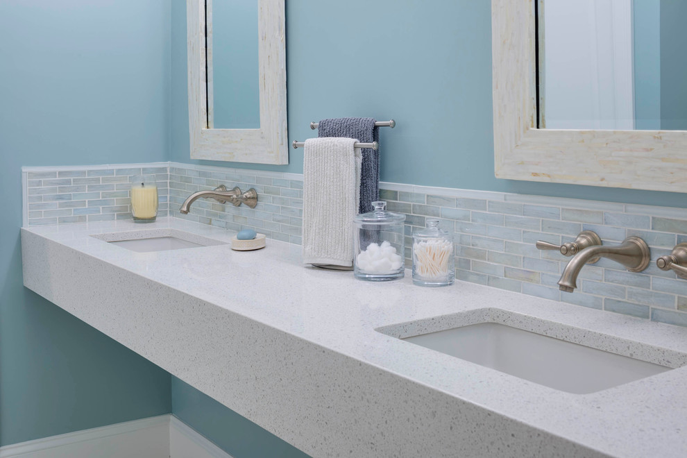 На фото: главная ванная комната среднего размера в стиле модернизм с подвесной раковиной, столешницей из переработанного стекла и синими стенами с