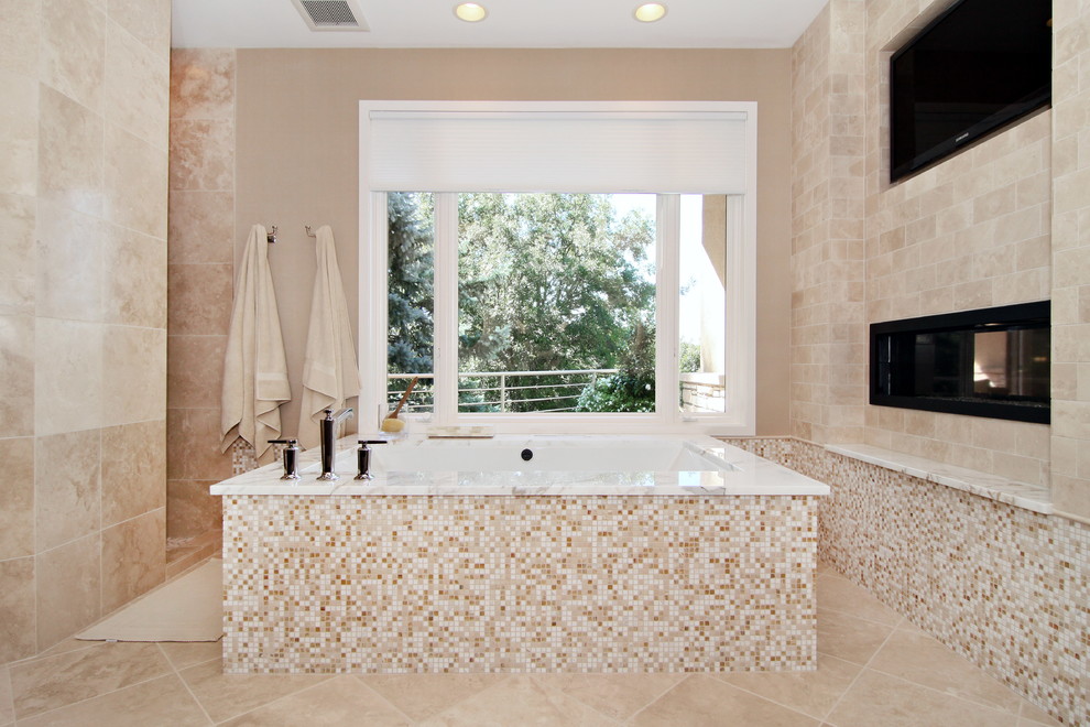 Cette photo montre une salle de bain chic avec une baignoire encastrée et un carrelage beige.