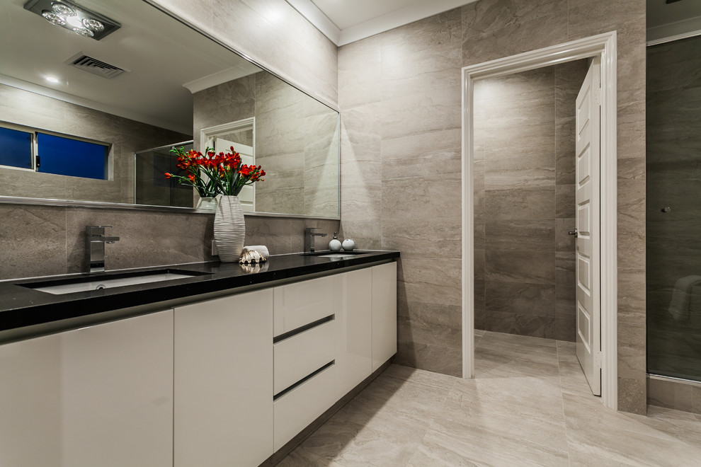 Inredning av ett modernt mellanstort badrum med dusch, med släta luckor, beige skåp, grå kakel, keramikplattor, grå väggar, klinkergolv i keramik, ett undermonterad handfat, bänkskiva i kvarts och grått golv