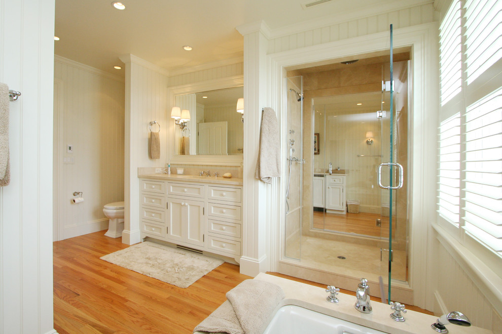 Inspiration for a huge coastal master light wood floor bathroom remodel in Boston with an undermount sink, white cabinets, granite countertops, a one-piece toilet, white walls and recessed-panel cabinets