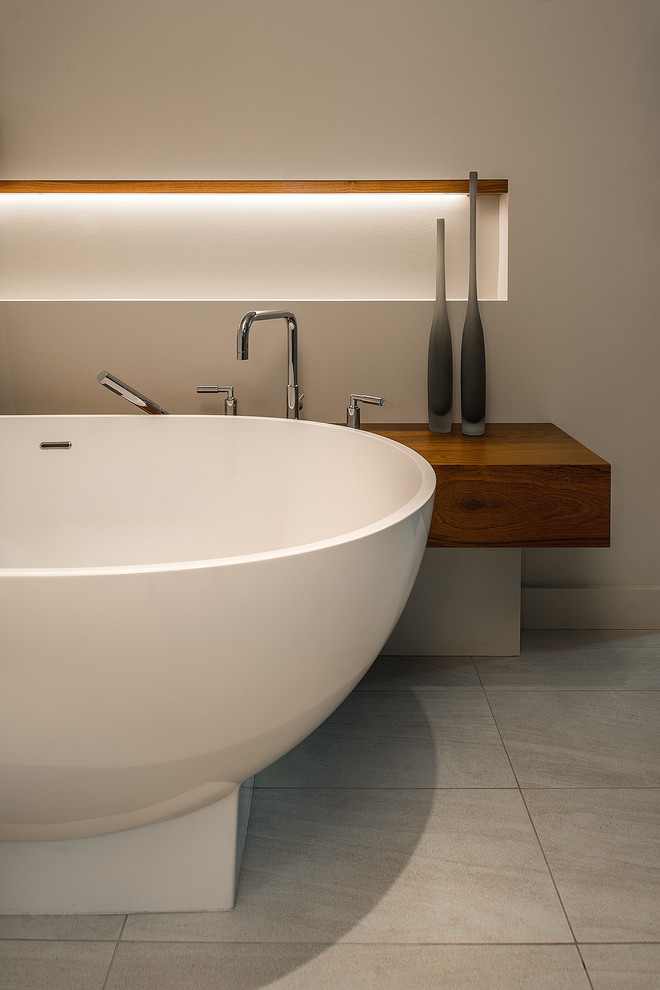 Immagine di una stanza da bagno padronale design di medie dimensioni con ante lisce, ante in legno scuro, vasca freestanding, piastrelle grigie e pareti beige