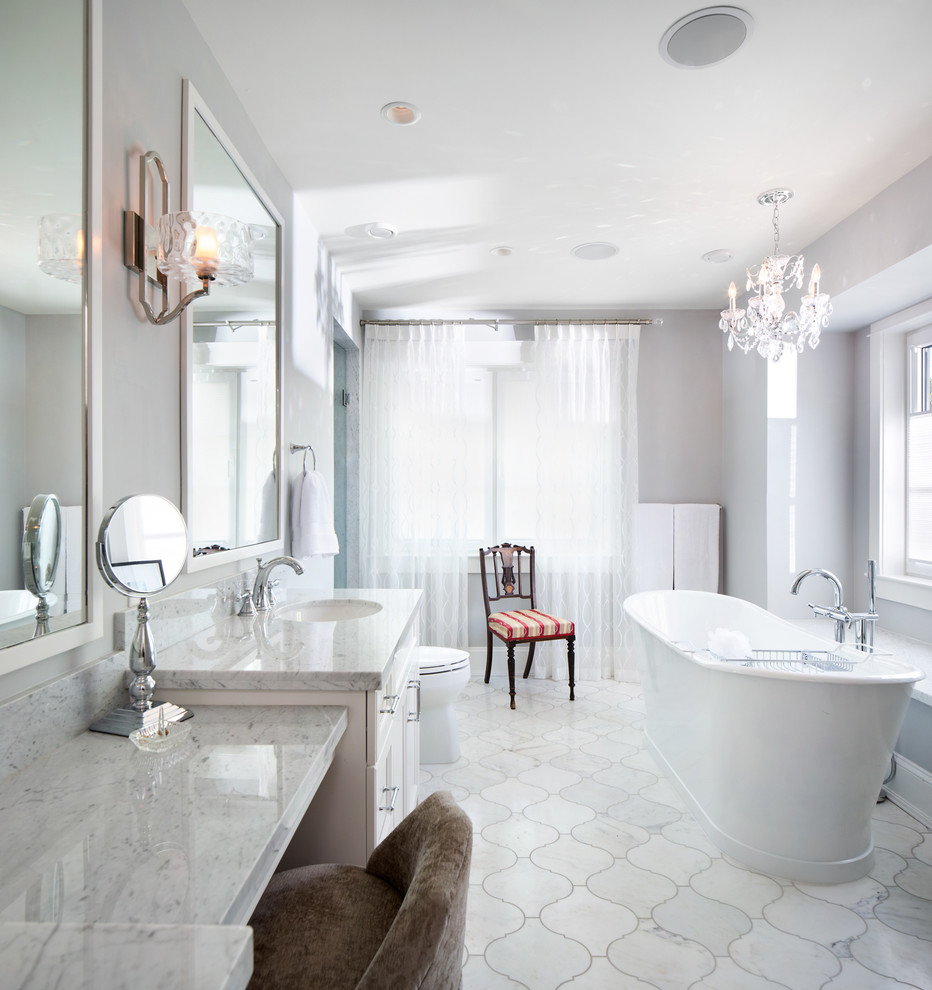 Exempel på ett mellanstort klassiskt en-suite badrum, med ett undermonterad handfat, luckor med infälld panel, vita skåp, bänkskiva i kvartsit, ett fristående badkar, en dusch i en alkov, en toalettstol med hel cisternkåpa, vit kakel, stenkakel och grå väggar
