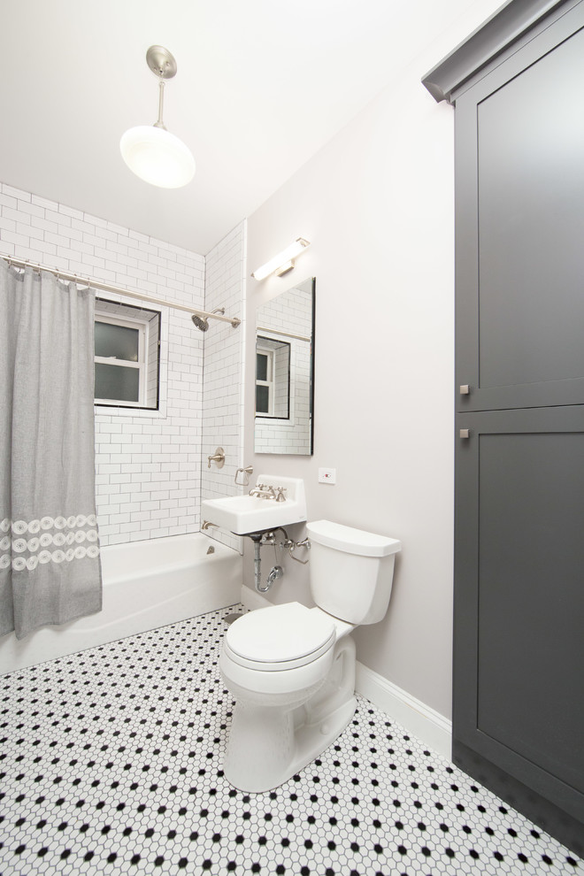 Bild på ett litet vintage en-suite badrum, med skåp i shakerstil, ett badkar i en alkov, en dusch/badkar-kombination, mosaikgolv, ett väggmonterat handfat, en toalettstol med separat cisternkåpa, vit kakel, tunnelbanekakel, grå väggar, bruna skåp och dusch med duschdraperi