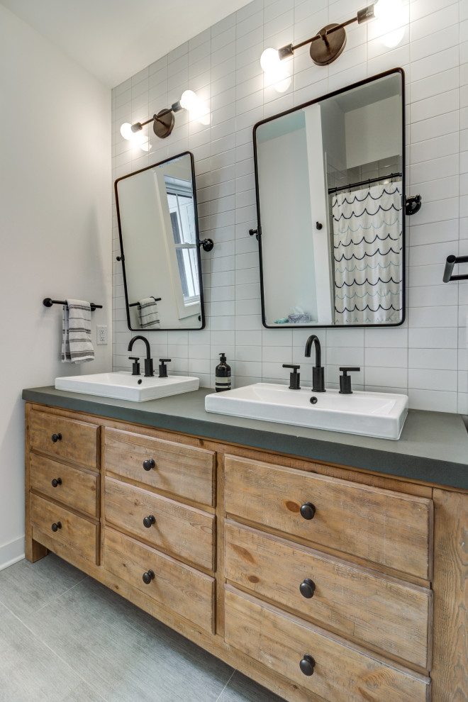 Example of a farmhouse kids' white tile and subway tile ceramic tile, gray floor and double-sink alcove bathtub design in Cleveland with flat-panel cabinets, distressed cabinets, white walls, concrete countertops, gray countertops and a freestanding vanity