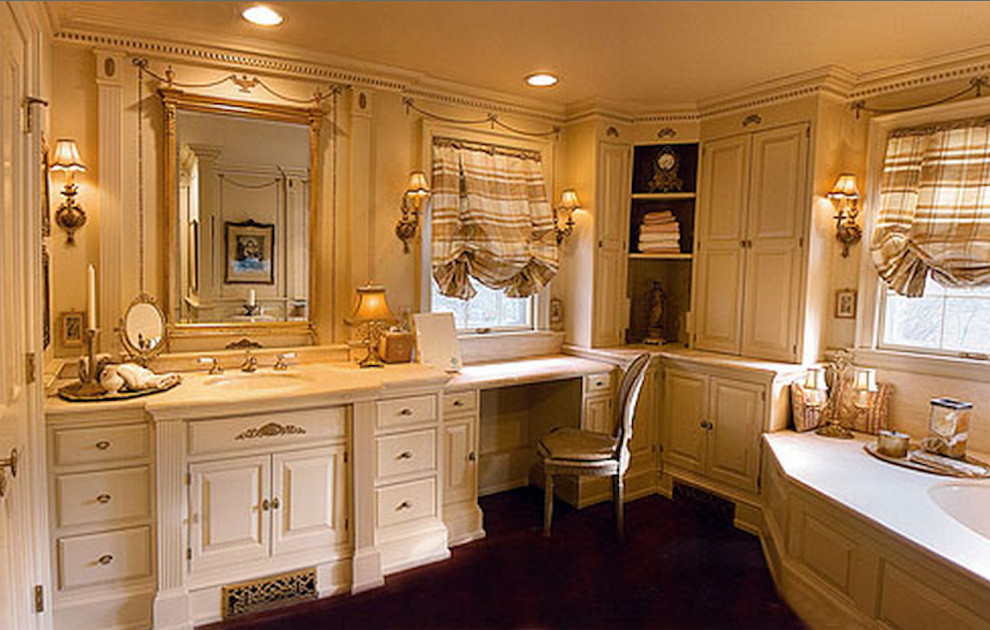 Example of a large classic master dark wood floor corner bathtub design in Philadelphia with raised-panel cabinets, beige cabinets, a two-piece toilet, a drop-in sink and beige walls
