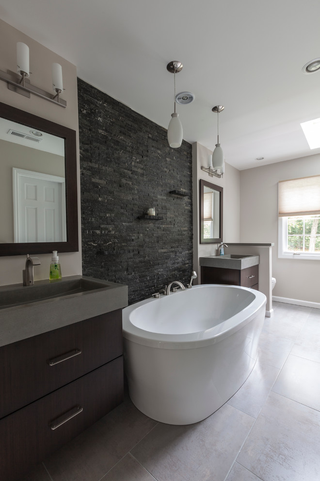 Large urban master gray tile and porcelain tile porcelain tile bathroom photo in Bridgeport with an integrated sink, flat-panel cabinets, dark wood cabinets, concrete countertops, a two-piece toilet and gray walls