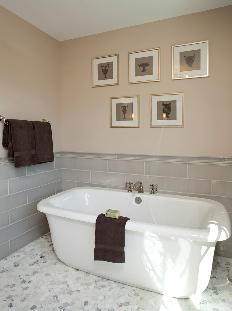 На фото: огромная главная ванная комната в стиле неоклассика (современная классика) с фасадами с утопленной филенкой, темными деревянными фасадами, мраморной столешницей и серой плиткой