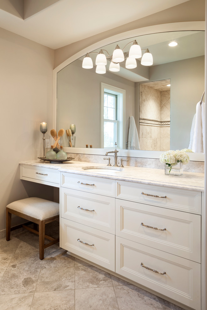 На фото: главная ванная комната в классическом стиле с белыми фасадами, мраморной столешницей, душем без бортиков, бежевой плиткой, каменной плиткой, бежевыми стенами и полом из керамической плитки с