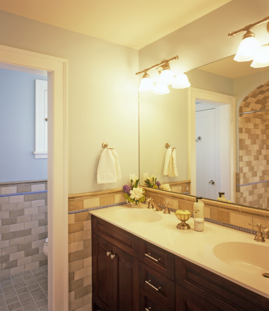 This is an example of a medium sized traditional ensuite bathroom in Minneapolis with a submerged sink, flat-panel cabinets, dark wood cabinets, granite worktops, a submerged bath, grey tiles, beige walls, porcelain flooring, an alcove shower, a two-piece toilet and ceramic tiles.