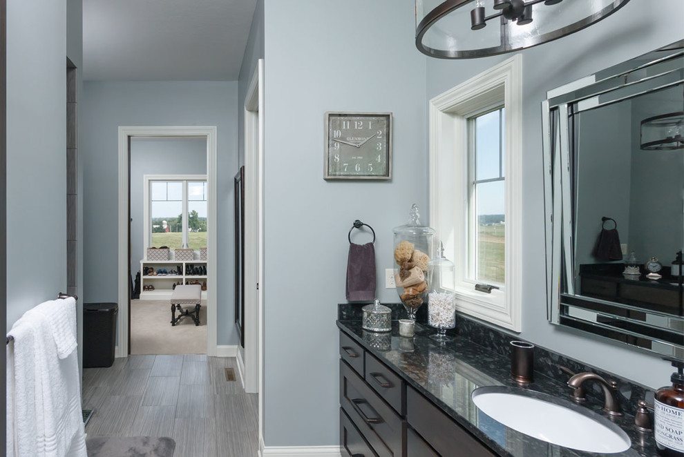 Country Badezimmer En Suite mit Schrankfronten im Shaker-Stil, dunklen Holzschränken, blauer Wandfarbe, hellem Holzboden und Unterbauwaschbecken in Cleveland
