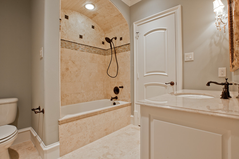 На фото: ванная комната среднего размера в классическом стиле с фасадами с выступающей филенкой, белыми фасадами, ванной в нише, душем над ванной, раздельным унитазом, бежевой плиткой, плиткой из листового камня, серыми стенами, полом из керамогранита, душевой кабиной, врезной раковиной, мраморной столешницей, бежевым полом и шторкой для ванной