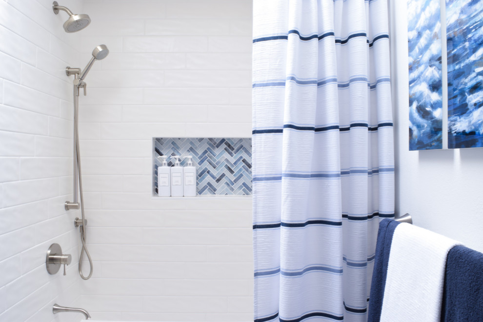 Inredning av ett modernt mellanstort vit vitt badrum, med blå skåp, ett badkar i en alkov, en dusch/badkar-kombination, en toalettstol med separat cisternkåpa, vit kakel, tunnelbanekakel, vita väggar, kalkstensgolv, ett undermonterad handfat, bänkskiva i akrylsten, grått golv och dusch med duschdraperi