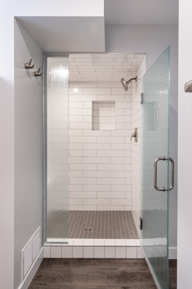 Foto på ett mellanstort vintage grå badrum med dusch, med skåp i shakerstil, vita skåp, en öppen dusch, en toalettstol med separat cisternkåpa, vit kakel, tunnelbanekakel, grå väggar, laminatgolv, ett nedsänkt handfat, granitbänkskiva, grått golv och dusch med gångjärnsdörr
