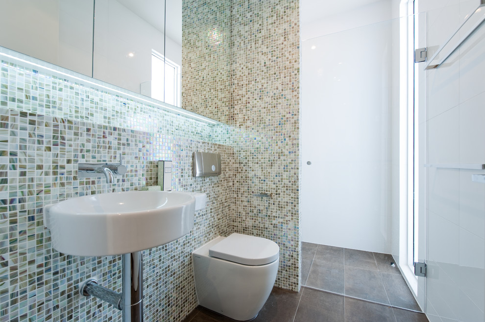 Foto di una stanza da bagno minimal con lavabo sospeso, ante con riquadro incassato, doccia alcova, WC monopezzo, piastrelle a mosaico e pavimento in gres porcellanato