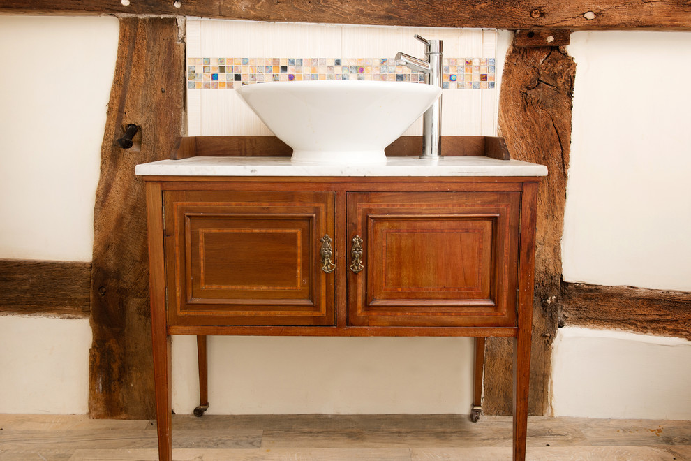 Inspiration pour une salle de bain rustique en bois brun avec un placard en trompe-l'oeil et une baignoire sur pieds.