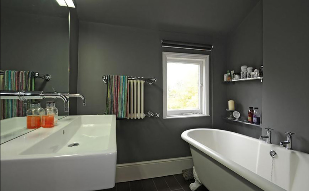 Inredning av ett modernt litet badrum för barn, med ett badkar med tassar, våtrum, en vägghängd toalettstol, grå kakel, travertinkakel, grå väggar, klinkergolv i porslin, ett väggmonterat handfat, brunt golv och med dusch som är öppen