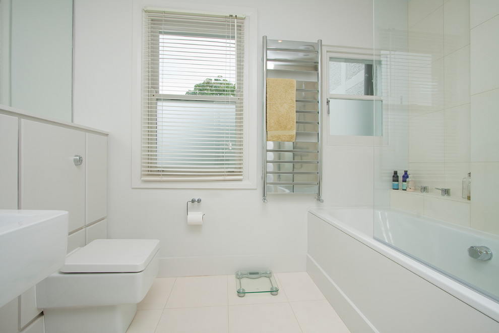 Modernes Badezimmer mit Wandwaschbecken, Kalkstein-Waschbecken/Waschtisch, Badewanne in Nische, Duschbadewanne, weißen Fliesen und Keramikfliesen in London