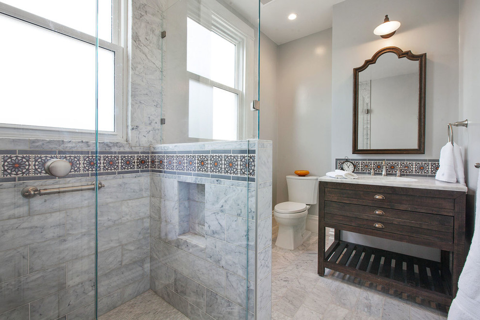 Contemporary ensuite bathroom in San Francisco with dark wood cabinets, marble worktops, grey walls, marble flooring, a two-piece toilet, grey tiles, freestanding cabinets, a corner shower, marble tiles, grey floors and a hinged door.