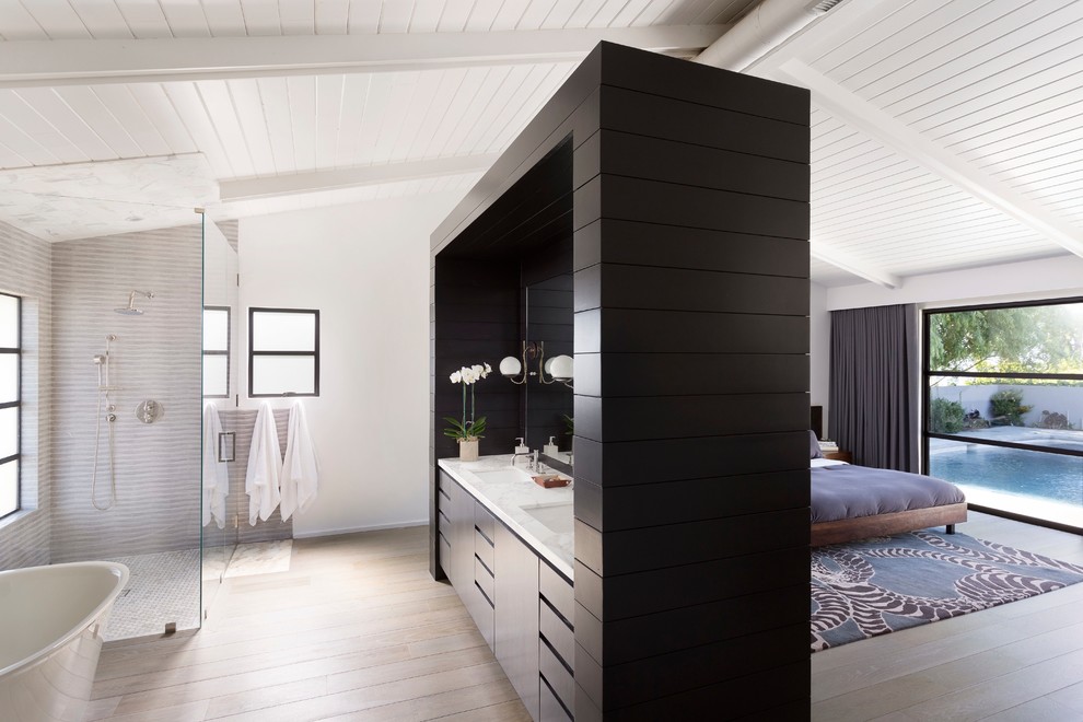 Exempel på ett 50 tals en-suite badrum, med ett undermonterad handfat, släta luckor, svarta skåp, ett fristående badkar, en kantlös dusch, grå kakel, vita väggar och ljust trägolv