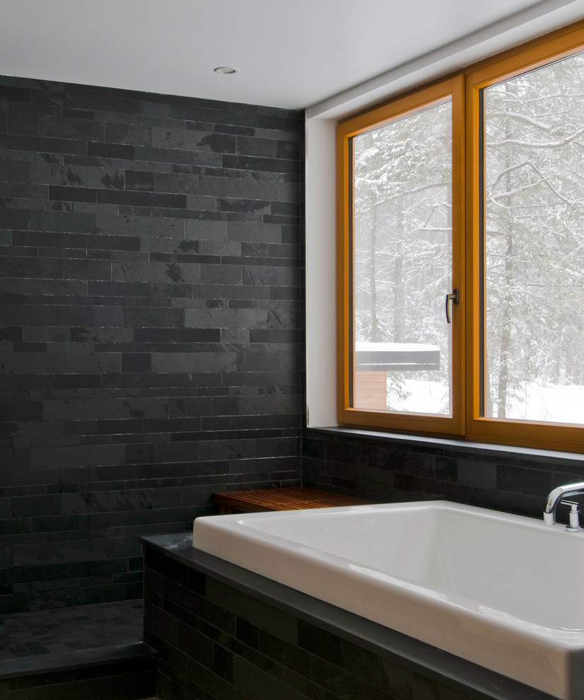 This is an example of a large contemporary ensuite bathroom in Toronto with a built-in bath, black tiles, stone tiles, black walls and slate flooring.
