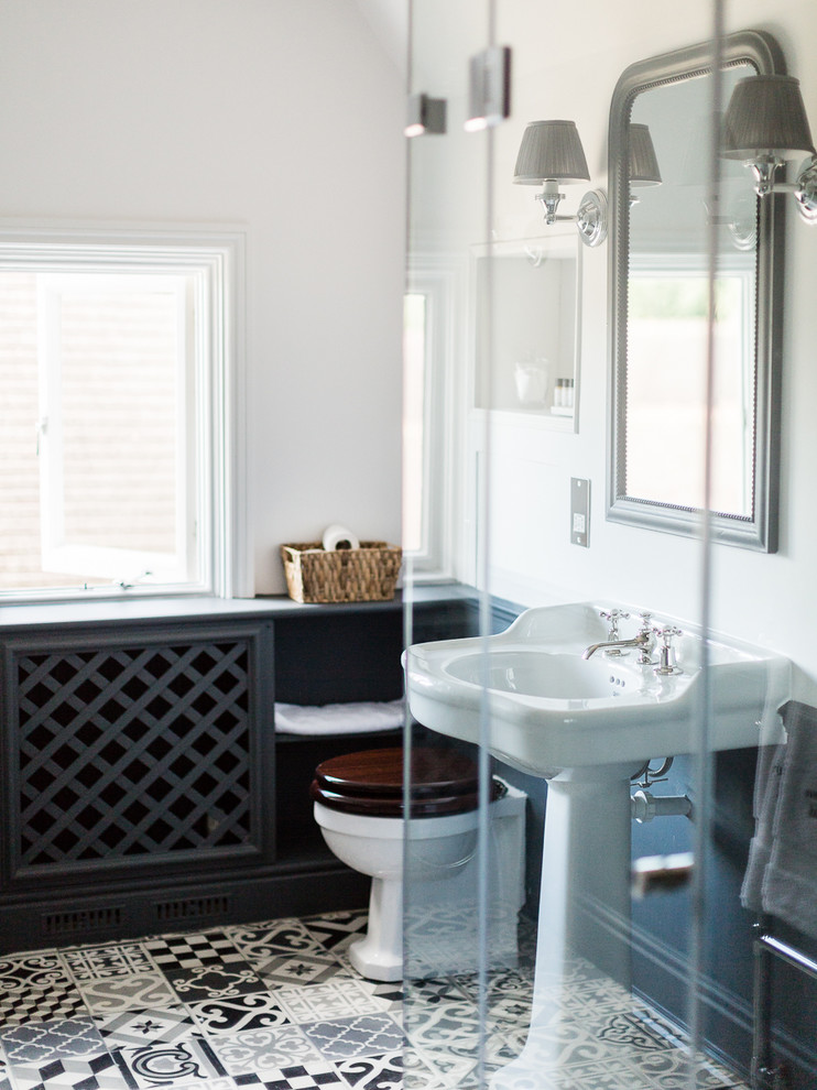 Klassisk inredning av ett mellanstort badrum med dusch, med ett fristående badkar, en öppen dusch, en toalettstol med hel cisternkåpa, svart och vit kakel, cementkakel, flerfärgade väggar, klinkergolv i keramik och ett konsol handfat