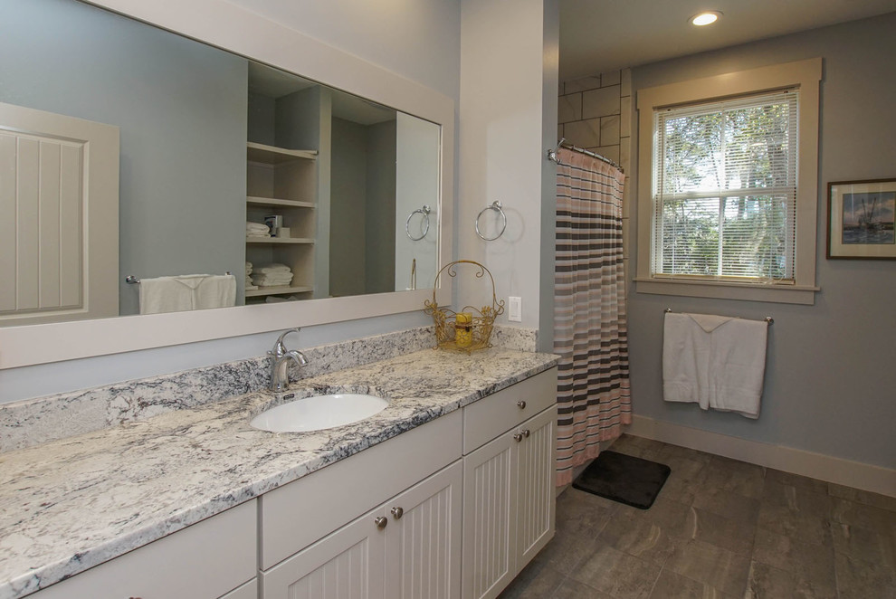 Bathroom - large coastal 3/4 gray tile and ceramic tile ceramic tile bathroom idea in Charleston with shaker cabinets, white cabinets, blue walls, an undermount sink and granite countertops