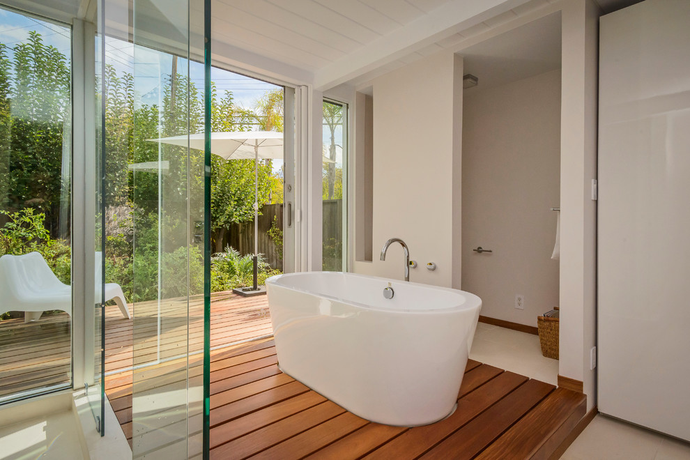 Immagine di una stanza da bagno moderna con vasca freestanding, doccia ad angolo e pareti beige