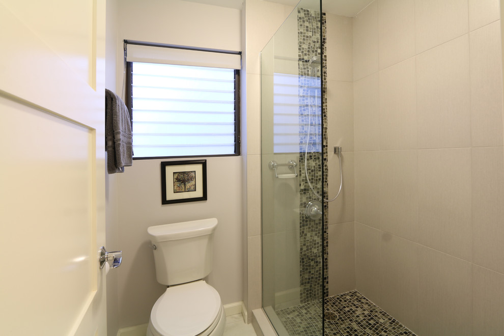 Diseño de cuarto de baño principal tropical de tamaño medio con ducha empotrada, sanitario de dos piezas, baldosas y/o azulejos blancos, paredes blancas y suelo con mosaicos de baldosas
